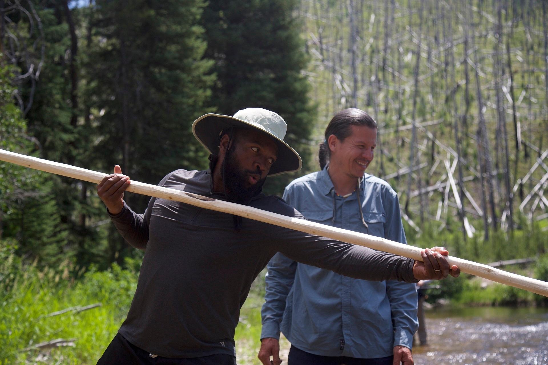 Baratunde Thurston holding a fishing spear on the Salmon River with Sammy Matsaw in Pocatello, ID